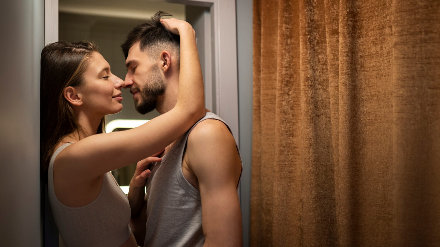 Couple passionné s'embrassant dans un couloir, représentant l'intensité des rencontres secrètes et de l'infidélité en ligne évoquées dans l'article