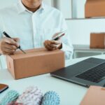 business teenager is looking on tablet and writing a customer address contact to deliver