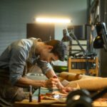 Focused craftsman intently working on a leather project in his local workshop
