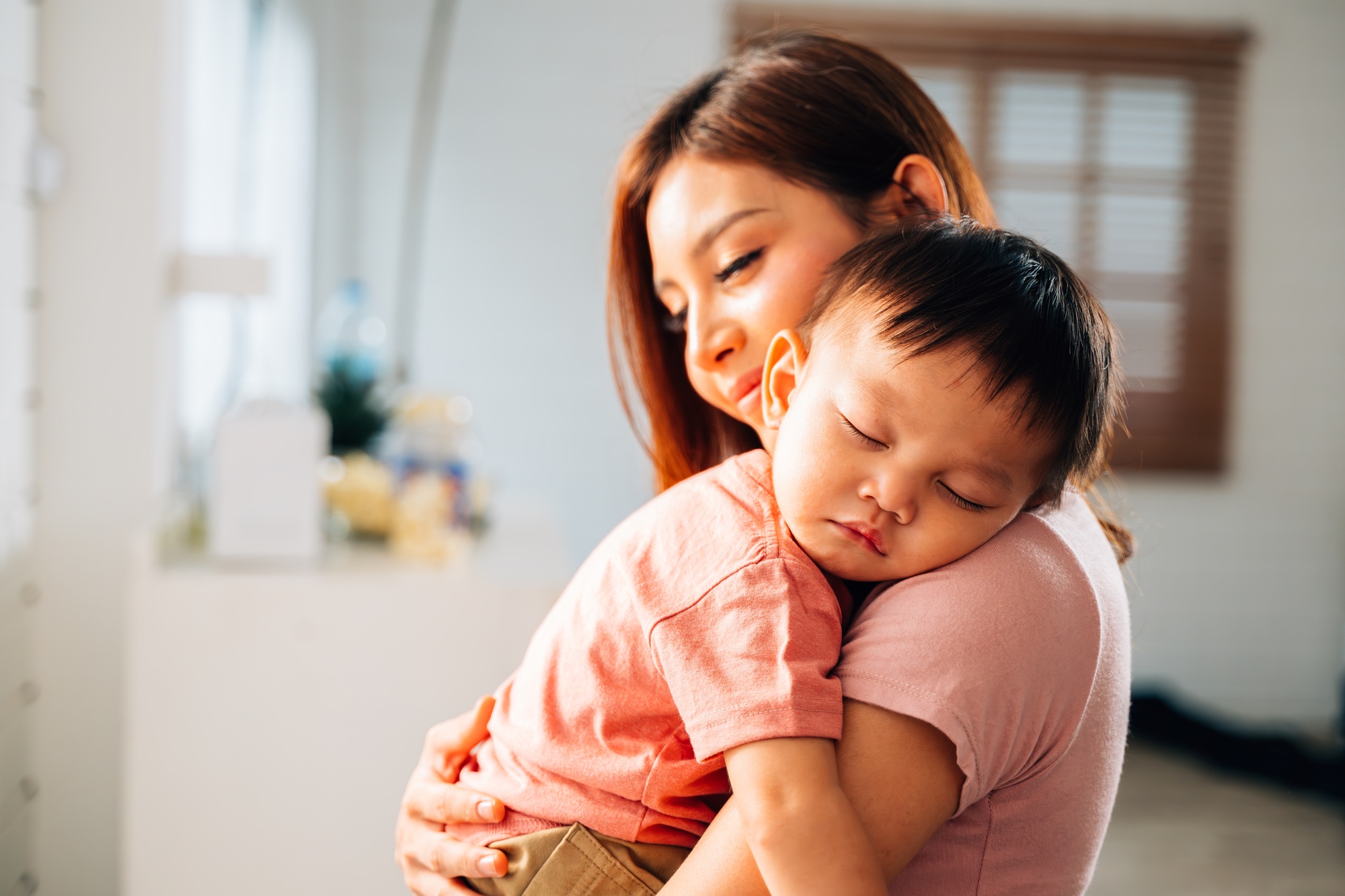 Happy mother and hugging embracing little son with love and care