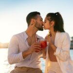Loving ethnic couple kissing on seafront