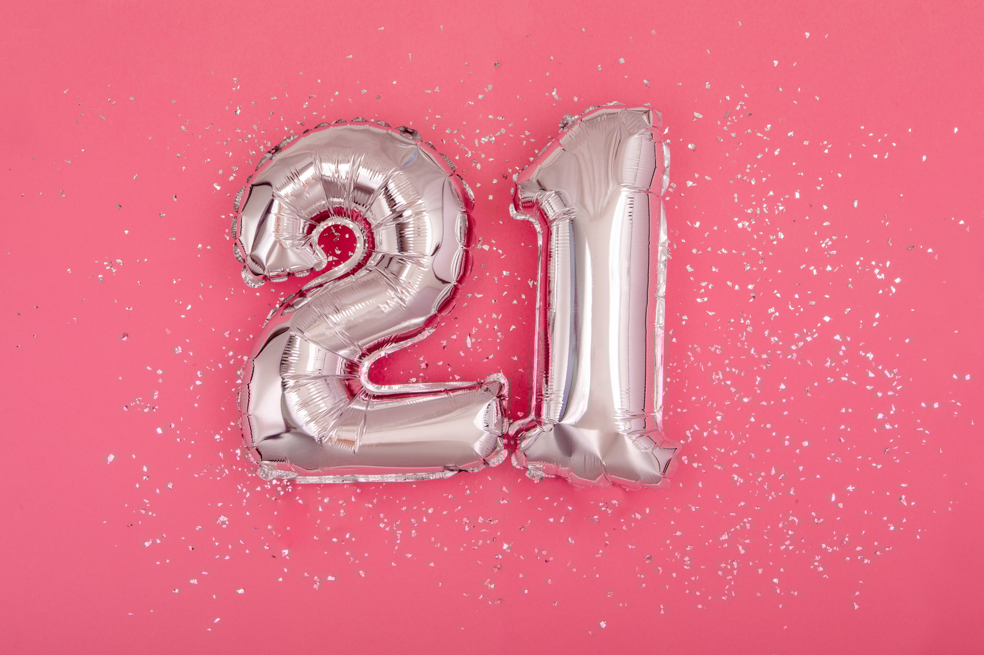 Silver balloon shape of number twenty one 21 pink background